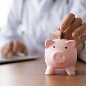 A doctor saving money in a piggy bank - Mateskon Law.
